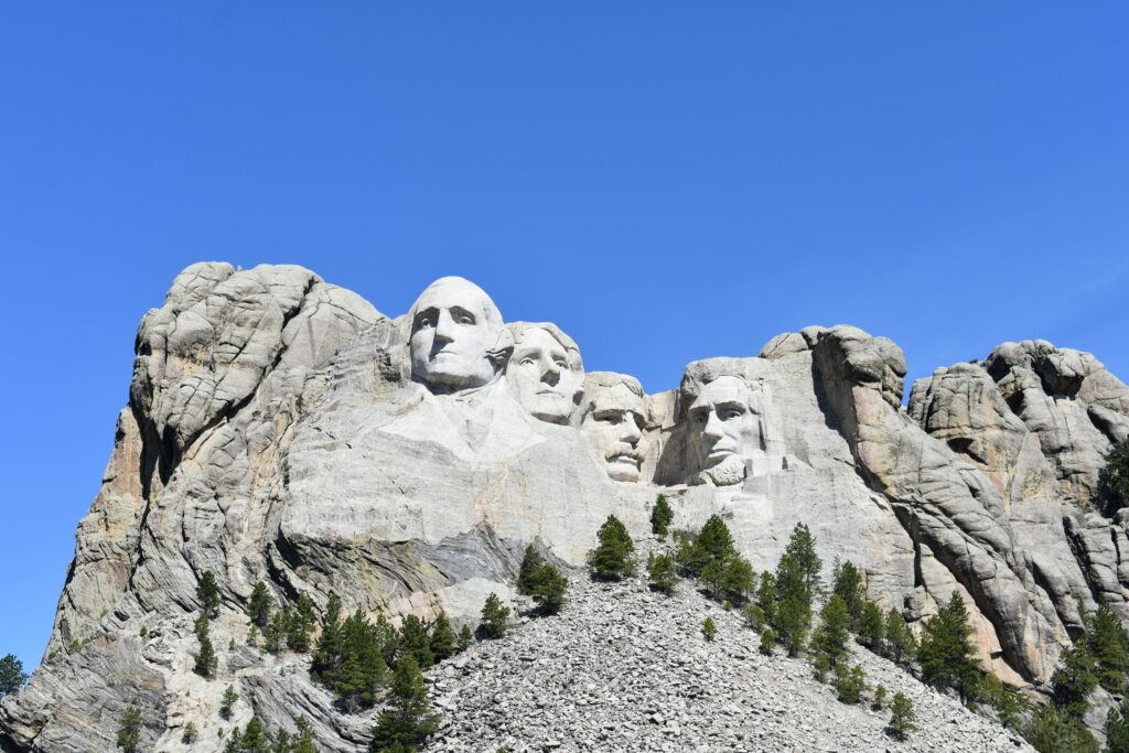 Mount Rushmore featuring presidential sculptures against a clear blue sky.